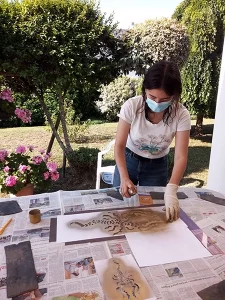 Photo de Chloé Tuffigo, cosplayeuse, avec une bombe de peinture et un pochoir, réalisant la tenue des profondeurs de Link du jeu The Legend of Zelda : Tears of the Kingdom